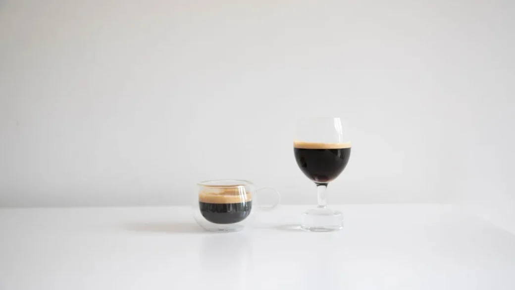 A single and double espresso basket placed side by side showing the depth difference