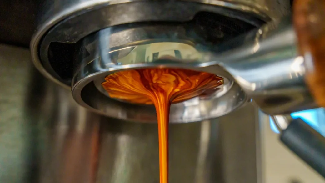 A slow honey-colored espresso stream from a bottomless portafilter